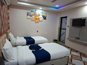a hotel room with two beds and a flat screen tv at Hotel Dev Inn in Dhangadhi