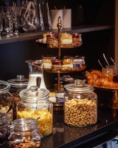 ein Buffet mit Gläsern voller Speisen, Gebäck und Brot in der Unterkunft Hotel Pietryna in Łódź