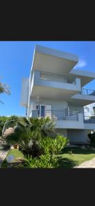 a tall white building with a palm tree in front of it at Villas Kavouri in Kryonéri