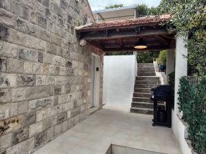 a building with a stone wall and a stairway at Holiday Home Magazin in Slano