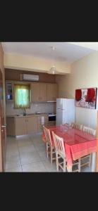 a kitchen with a red table and chairs and a refrigerator at Villas Kavouri in Kryonéri