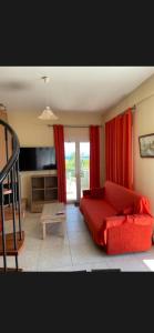 a bedroom with a red bed and red curtains at Villas Kavouri in Kryonéri