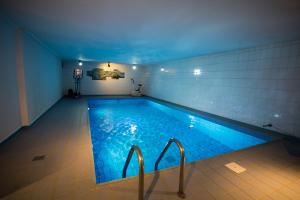 a large swimming pool with blue lights in a room at Hotel Am Sportpark in Duisburg