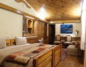 a bedroom with a large bed with a wooden ceiling at Shantiniketan Mountain Home in Almora