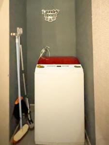 a small white refrigerator in a room with a guitar at Tafufu Villa Tumpak Sewu in Sumberbopong
