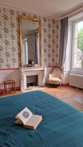a bedroom with a bed with a book and a mirror at Le Château de La Coste in Saint-Julien +34 photos