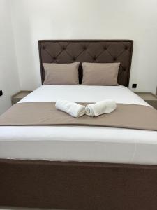 a bed with two white towels on it at Miri Apartments in Ulcinj