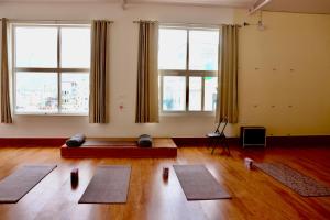 a room with mats on the floor in front of windows at Aarunya Stays in Rishīkesh