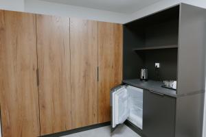 a kitchen with wooden cabinets and a white refrigerator at ŠD Jedlíkova 9 in Košice