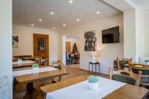 a living room with tables and chairs and a television at Weingut Erich Serwazi in Mesenich