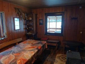 a bedroom with a bed and a window at Bajorinų sodyba in Varėna