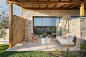 a patio with a couch and a table at TERTH - Afytos Experience in Afitos