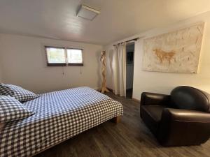 a bedroom with a bed and a couch and a chair at Le Gecko in Saint-Victor-la-Coste +20 photos