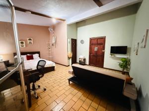 a bedroom with a bed and a desk in a room at Quepos Prime in Quepos