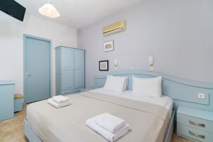 a bedroom with a large bed with towels on it at Archodissa Pansion in Alyki