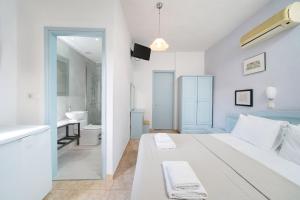 a white bedroom with a large bed and a bathroom at Archodissa Pansion in Alyki +59 photos