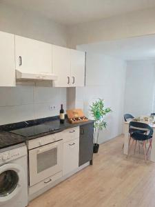 a kitchen with white cabinets and a dishwasher at La Casita de Suances 1- Jardín y Parking, Ideal Familias y Mascotas in Suances