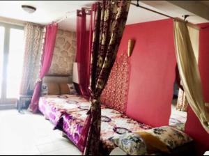 a bedroom with a bed with pink walls and curtains at Jetset Parisian Holiday Home in Cesson