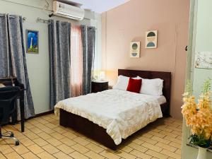 a bedroom with a bed with white sheets and red pillows at Quepos Prime in Quepos