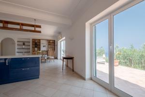 a large kitchen with a large sliding glass door at Tra Cielo e Mare & La Dépendance - Fantastic Sea View in Anacapri +65 photos