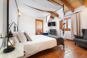 a bedroom with a white bed with a canopy at Finca - Agroturisme Sa Parellada in Binibona +68 photos