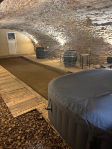 a room with a bed and a barrel in a cave at La Cave Des Merveilles in Mâcon +12 photos