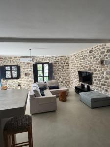 a living room with a couch and a tv at VillaAurora-mani in Areopoli