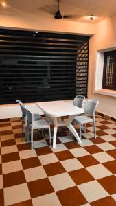 a dining room with a table and chairs on a checkered floor at Tamil Megam Villa in Chennai