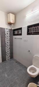 a bathroom with a toilet and a shower at Tamil Megam Villa in Chennai