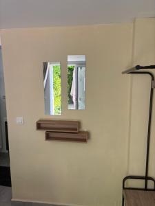 a wall with two mirrors on a white wall at Studio proche PARIS-orly in Sainte-Geneviève-des-Bois