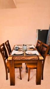 a wooden table with wooden chairs and a tableablish at Tamil Megam Villa in Chennai +16 photos