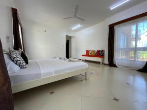 a white bedroom with a bed and a couch at Ocean Cliff Homes 4 bedroom shared apartment in Mombasa