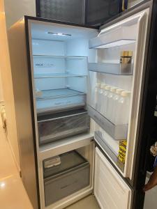 an empty refrigerator with its door open with its door at KD Homes in Surat