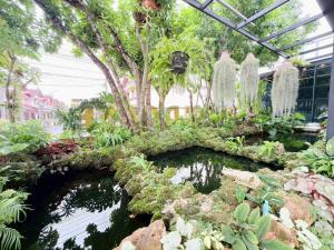 a garden with a pond in a greenhouse at The Gold Living Life in Thung Song