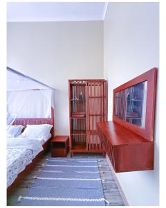 a bedroom with a bed and a dresser and a shelf at Winnie's Home in Morogoro