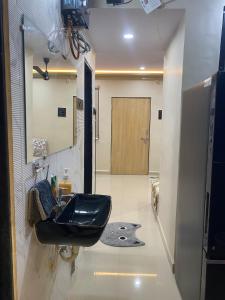 a bathroom with a black sink and a mirror at KD Homes in Surat