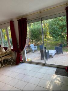 a living room with sliding glass doors and a patio at Jetset Parisian Holiday Home in Cesson