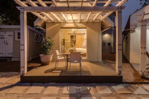 a patio with a table and chairs under a pergola at Mill Park Corner Cottages in Port Elizabeth