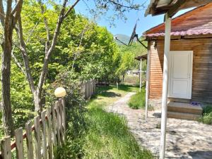 a wooden fence next to a house with a white door at Restaran otel in İsmayıllı