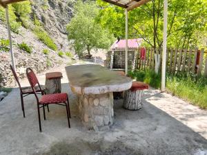 a stone table and two chairs sitting under a tent at Restaran otel in İsmayıllı
