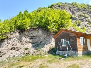 a small house in front of a mountain at Restaran otel in İsmayıllı
