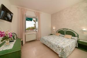 a bedroom with a bed and a window at Appartamenti Baia di Citara in Forio d'Ischia