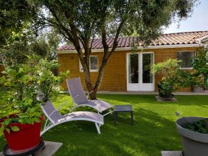 two chairs in the yard of a house at Chambre Cocon, bienvenue chez Sylviane in Marennes