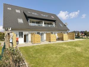 a house with wooden wicker chairs in the yard at Haus Inselperle mit Blick auf den Bodden in Alt Reddevitz