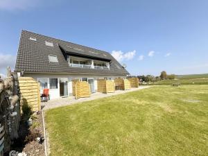 a house with yellow wicker chairs in a yard at Haus Inselperle mit Blick auf den Bodden in Alt Reddevitz