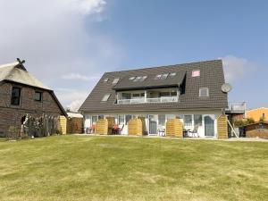 a house with a lawn in front of it at Haus Inselperle mit Blick auf den Bodden in Alt Reddevitz