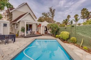 a backyard with a swimming pool and a house at Mill Park Corner Cottages in Port Elizabeth