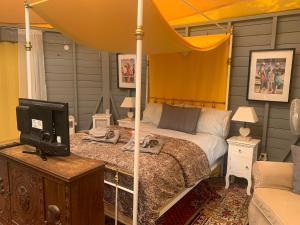 a bedroom with a bed and a tv on a table at The Yurt at Les Forges in Saint-Sornin-la-Marche +29 photos