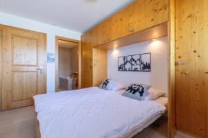 a bedroom with a large bed with wooden walls at Plein Ciel VA 022 - MOUNTAIN apartment 4 pers in Veysonnaz