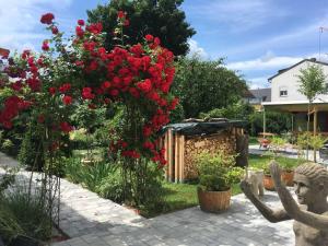 a statue in front of a bush of red roses at Ferien-Apartment Beller in Strullendorf